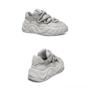 Light gray chunky streetwear sneakers viewed from the rear three-quarter angle with padded heel tab and distinctive wavy platform outsole