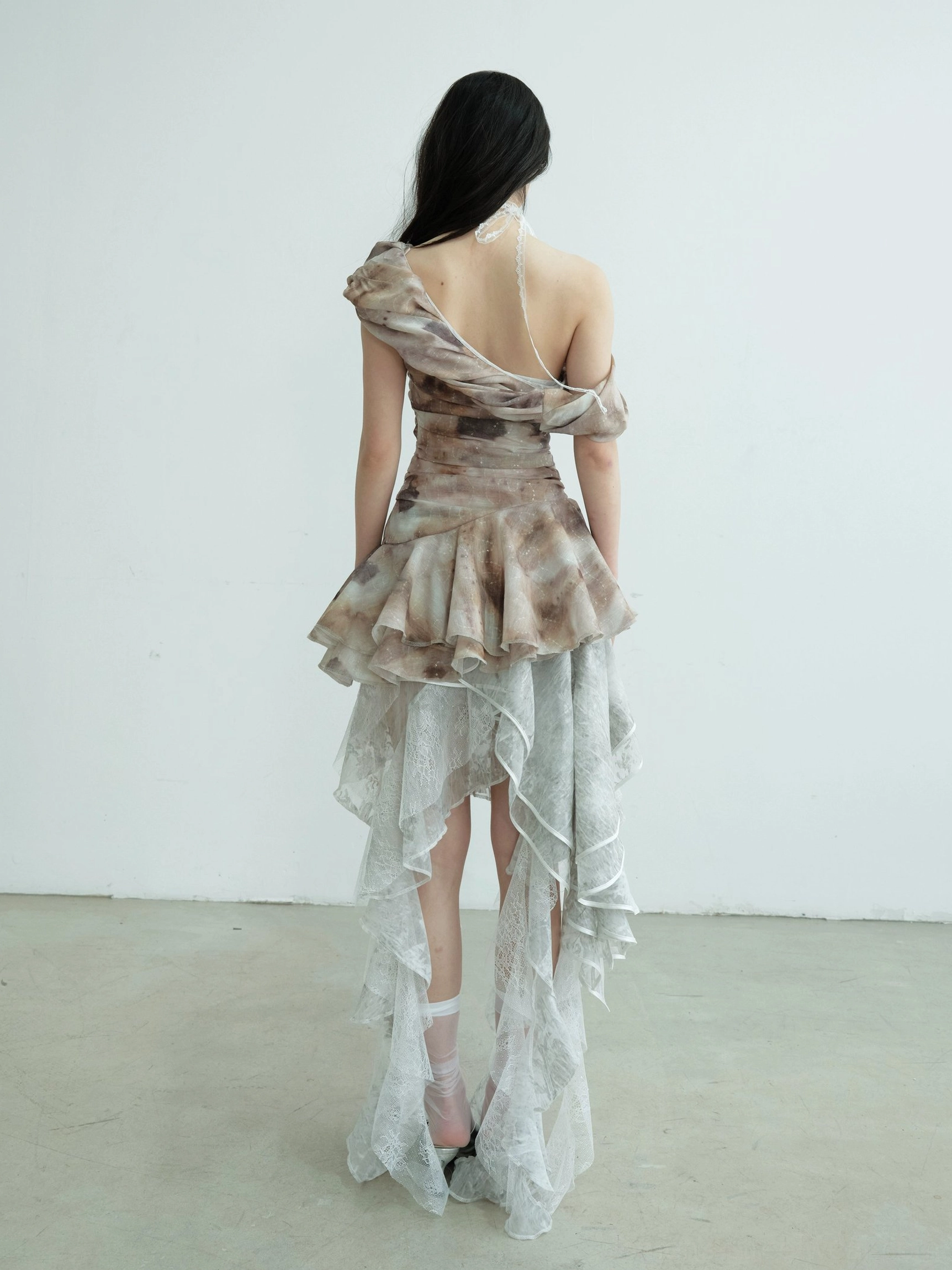 Back view fashion styling inspiration showing exposed back details and a long tiered ruffle hem for an asymmetric lace maxi skirt look