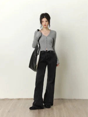 Light gray cropped V-neck ribbed knit cardigan styled with black wide-leg jeans and a tote bag in a minimalist studio