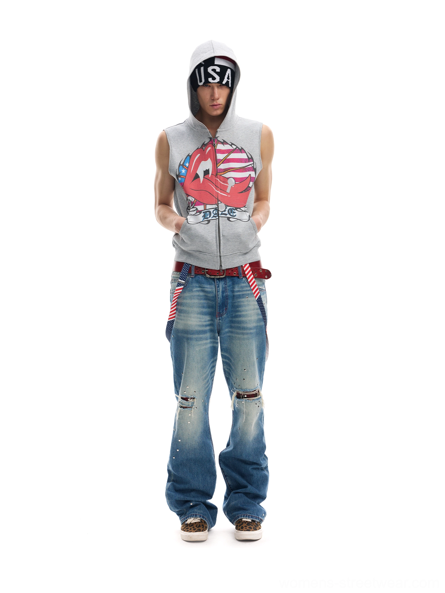 Male model wearing a light gray sleeveless zip-up hooded vest with lips flag graphic and distressed baggy jeans