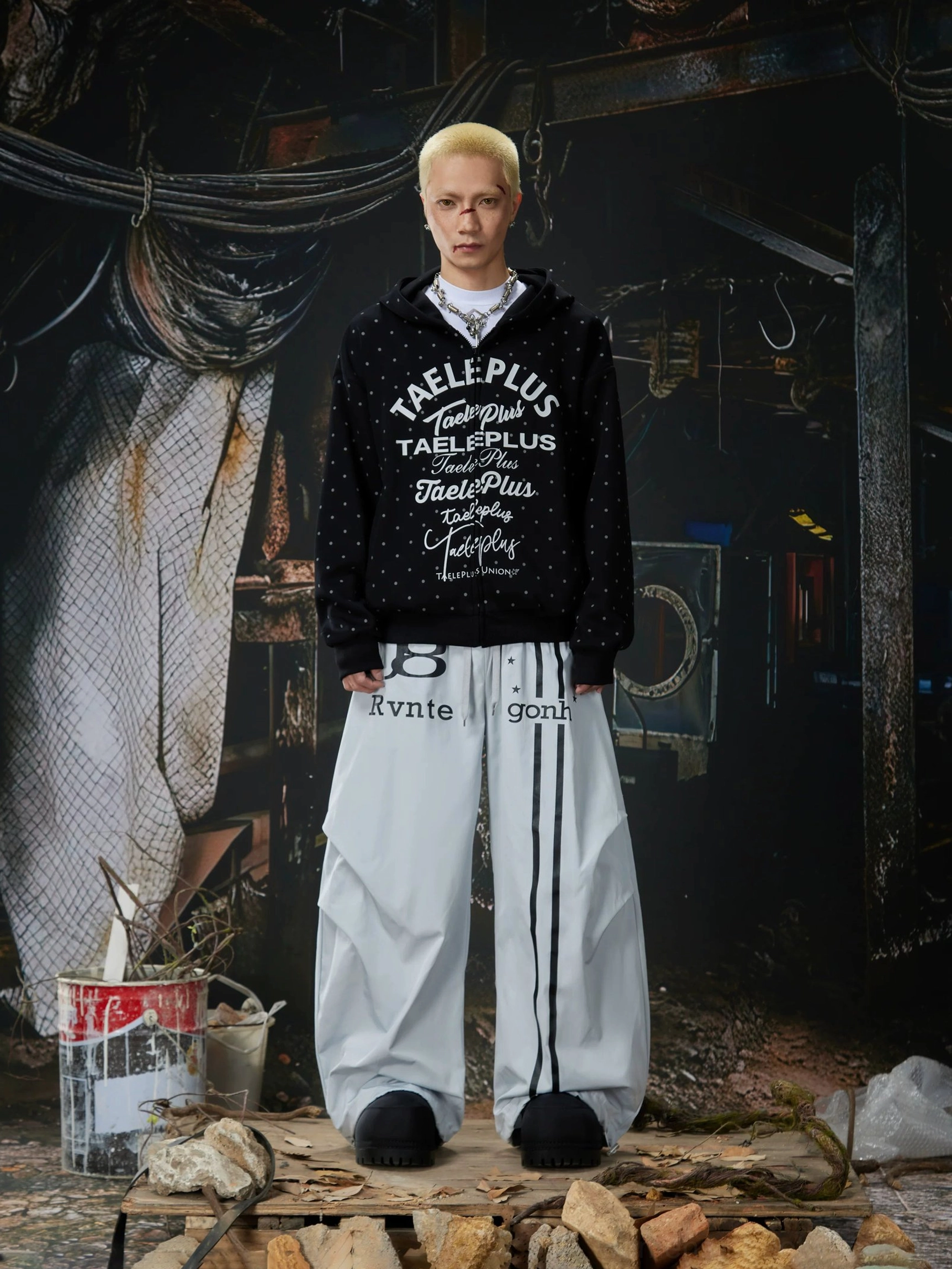 Light gray oversized track pants styled with a graphic hoodie and black slip-on shoes for a relaxed Korean streetwear outfit