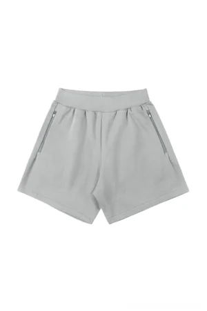 Light gray relaxed unisex streetwear shorts with ribbed elastic waistband and two secure angled zip pockets shown in a flat lay view