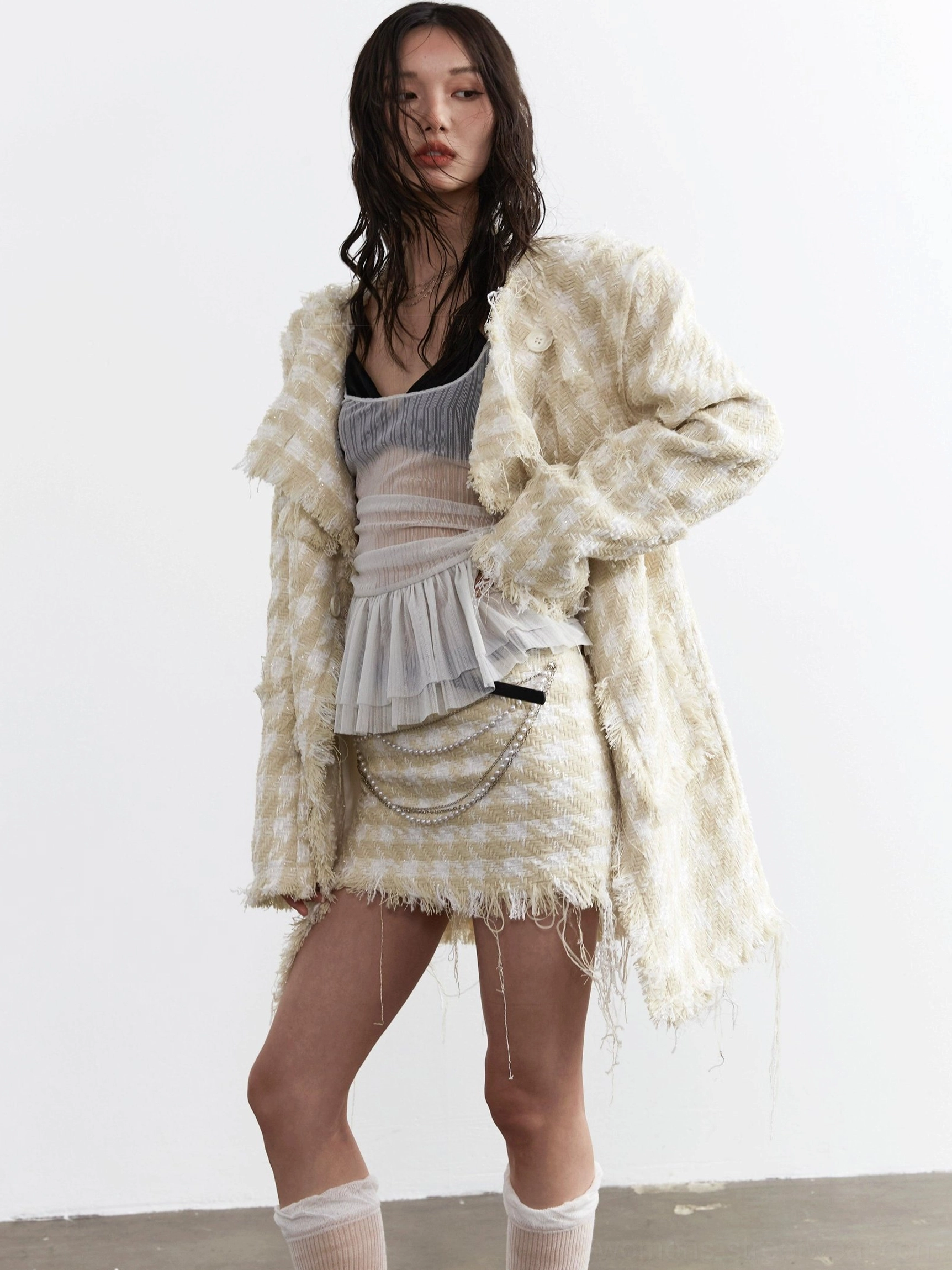 Three quarter view of light gray sheer pleated corset camisole with spaghetti straps and layered tulle ruffle peplum