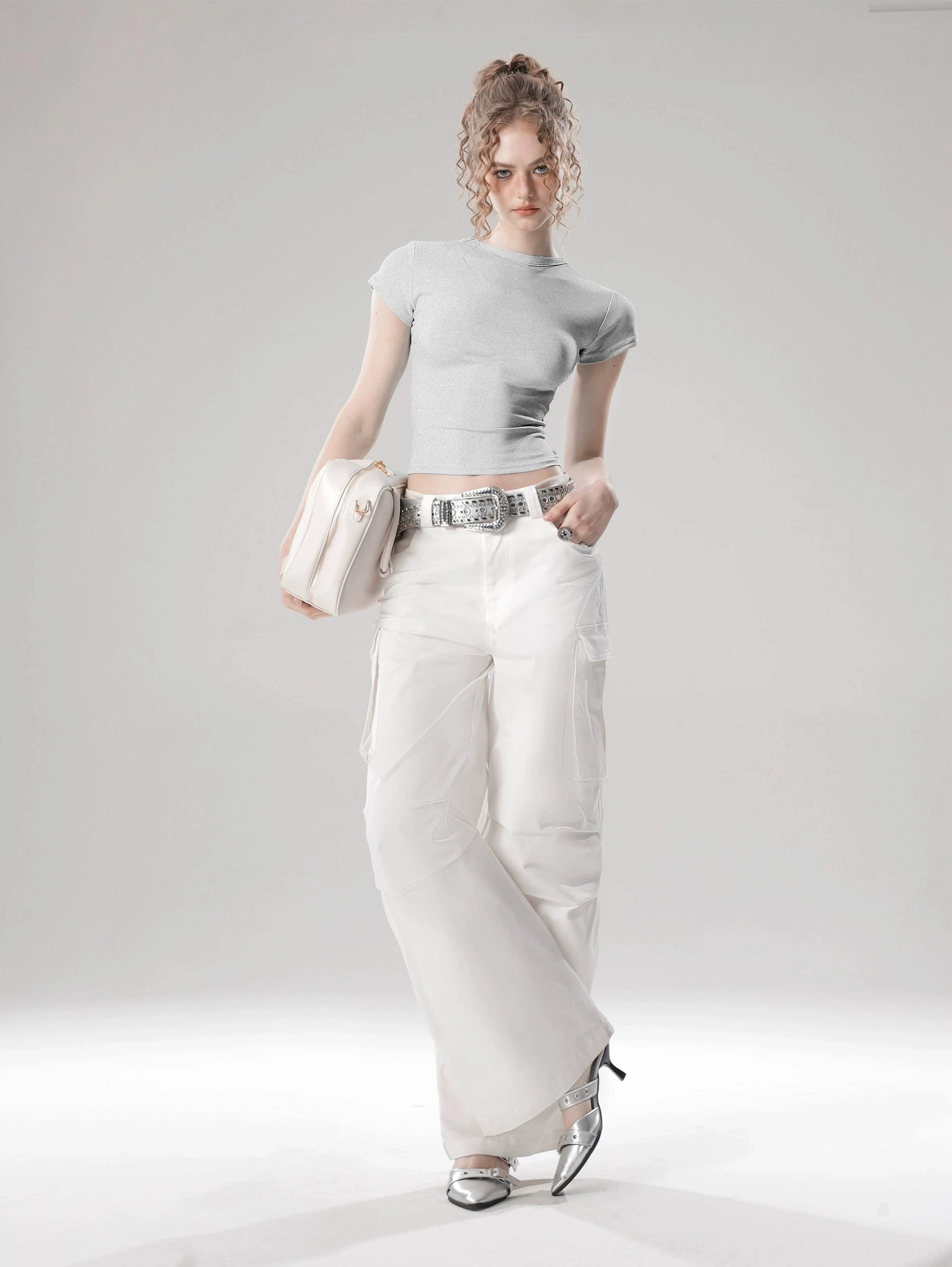 Light gray solid color cropped top with fitted silhouette styled with white wide-leg pants and beige shoulder bag