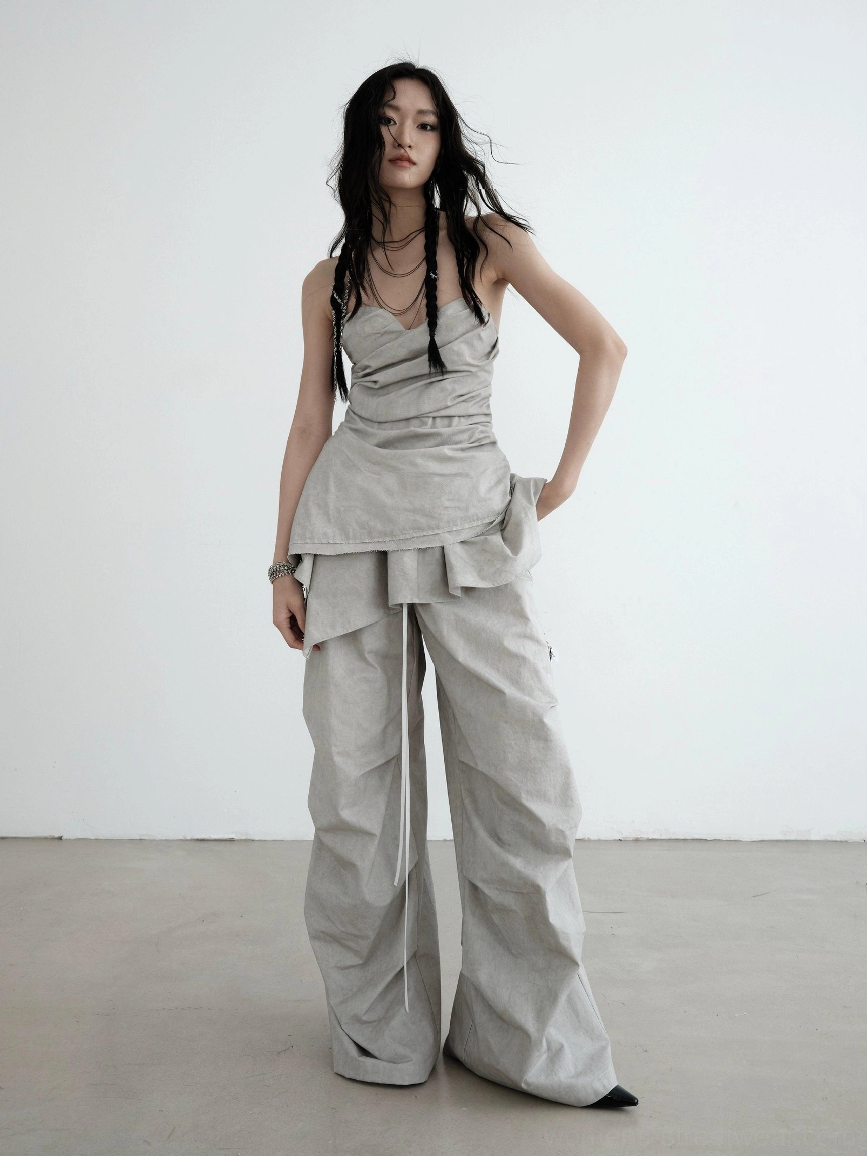 Light gray strapless ruched asymmetric draped top styled with wide-leg cargo pants in a full front streetwear outfit
