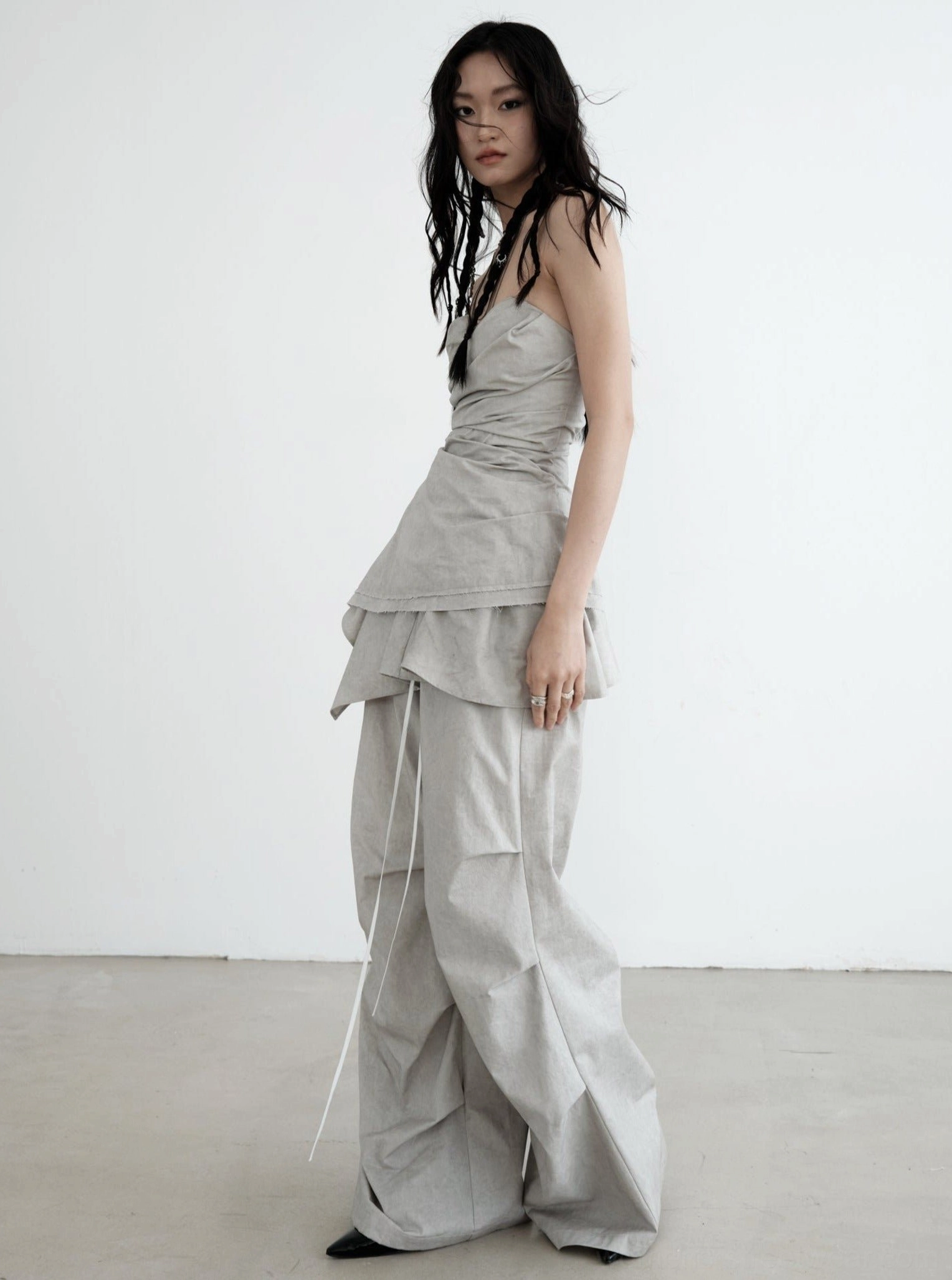 Side view of light gray wide-leg palazzo cargo pants showing relaxed oversized fit, flowing drape, and adjustable drawstring waist