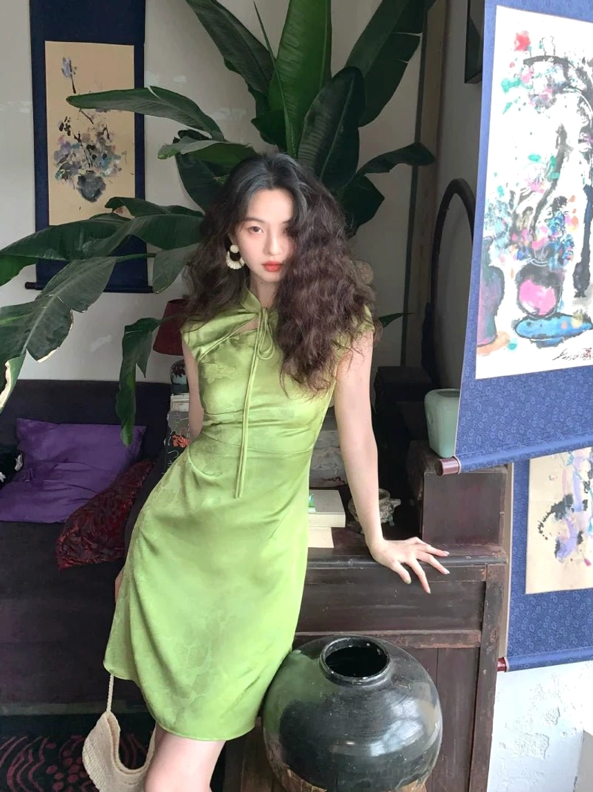 Light green satin cheongsam mini dress with high stand collar tie detail, sleeveless fitted mini silhouette, glossy East Asian streetwear fashion