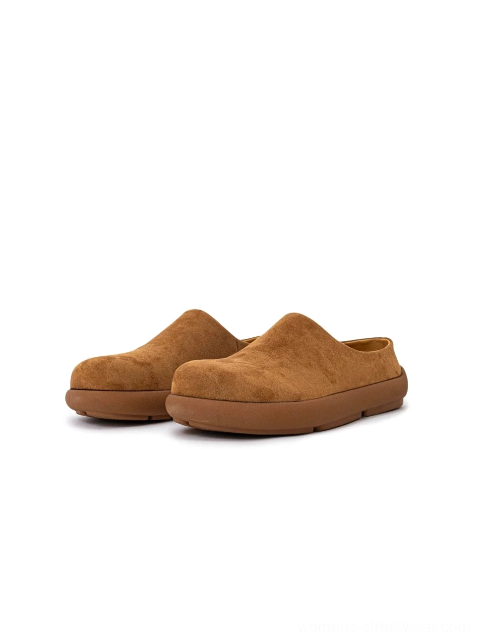 Pair of light tan suede mule clogs displayed from the front on a white background, showing the matching slip-on uppers and chunky rubber soles