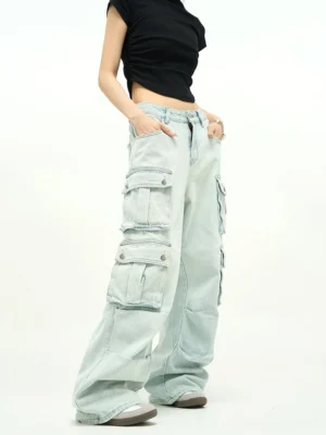 Light wash baggy cargo jeans shown in a three-quarter view with high-rise waist, extra-wide legs, oversized flap pockets, and faded blue cotton denim