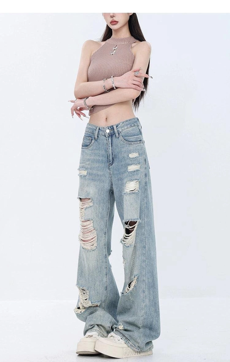 Light wash distressed high-waist wide-leg grunge jeans detailed product view with faded blue denim and intentional ripped accents