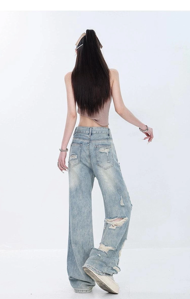 Relaxed back view of faded light blue distressed wide-leg jeans showing classic denim pockets and subtle lower-leg rips