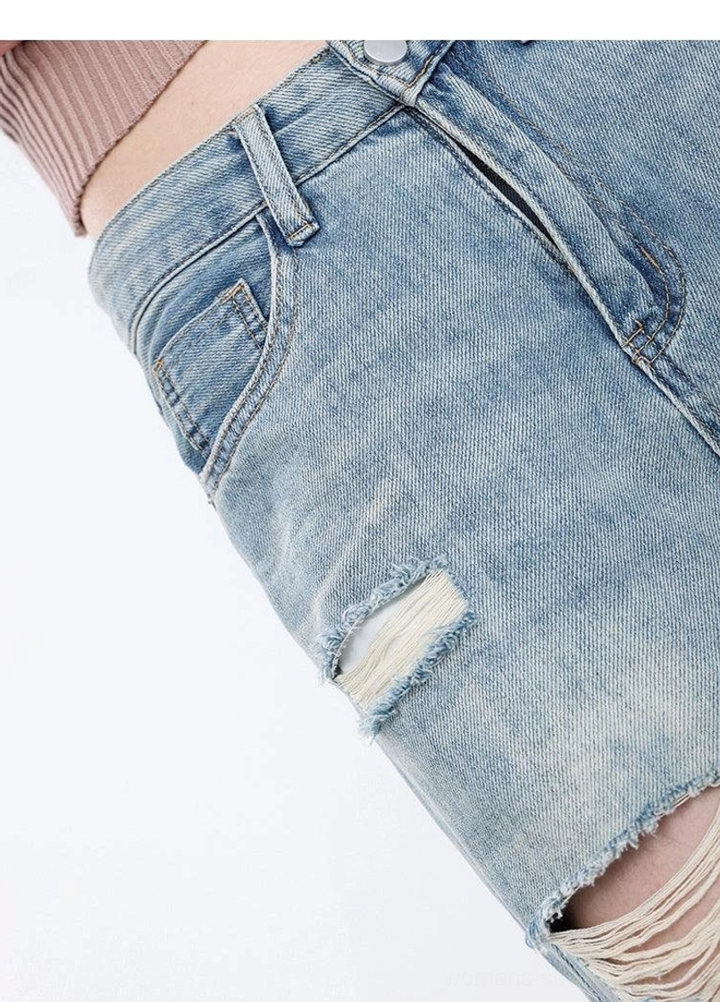 Light wash distressed high-waist wide-leg grunge jeans close-up showing ripped denim texture and faded wash finish