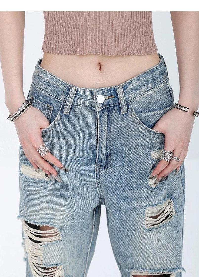 Light wash distressed high-waist wide-leg grunge jeans vintage denim texture and ripped streetwear detail view