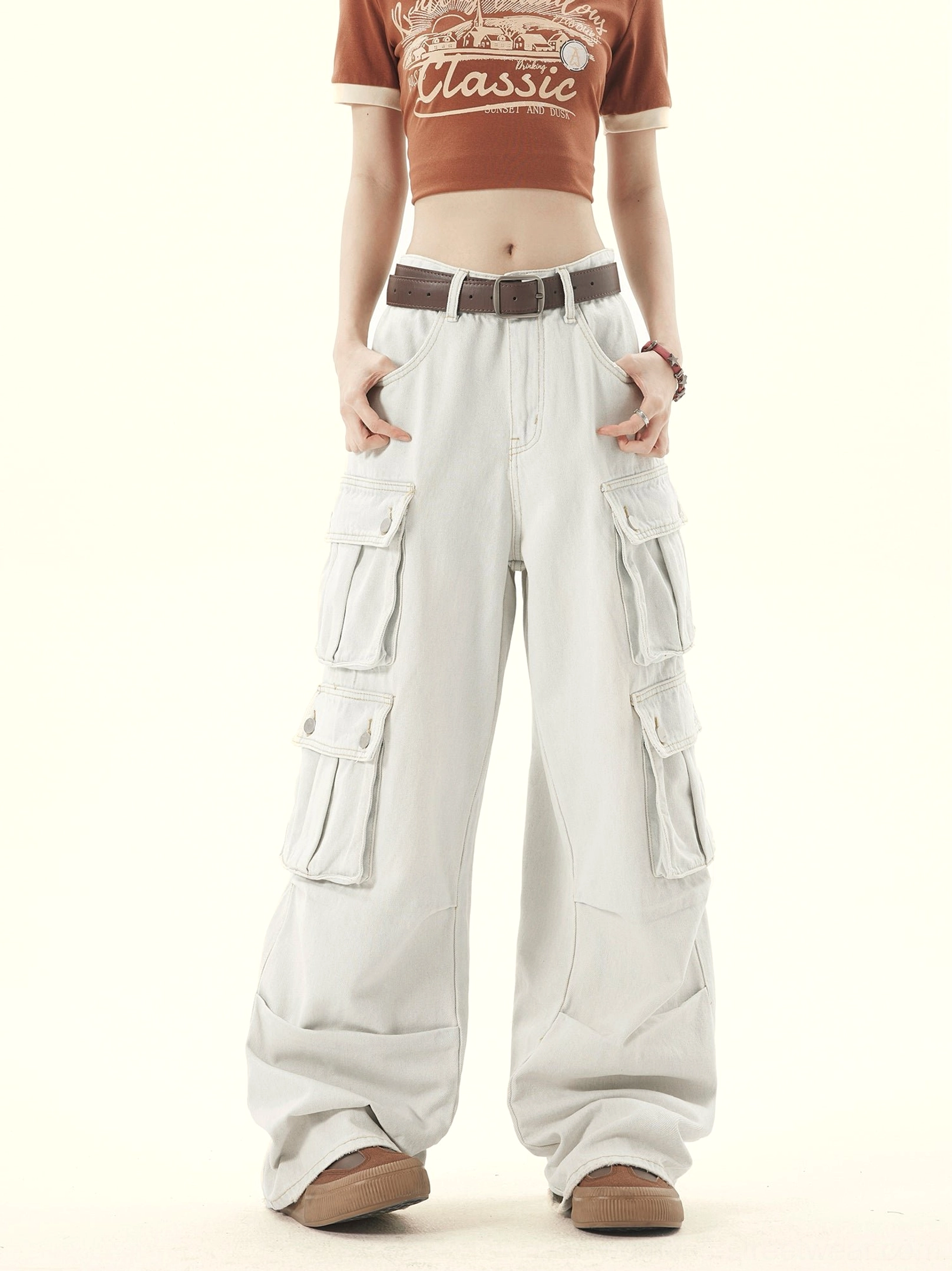 Front view of light gray washed denim wide leg cargo pants showing waistband belt loops and utility pockets