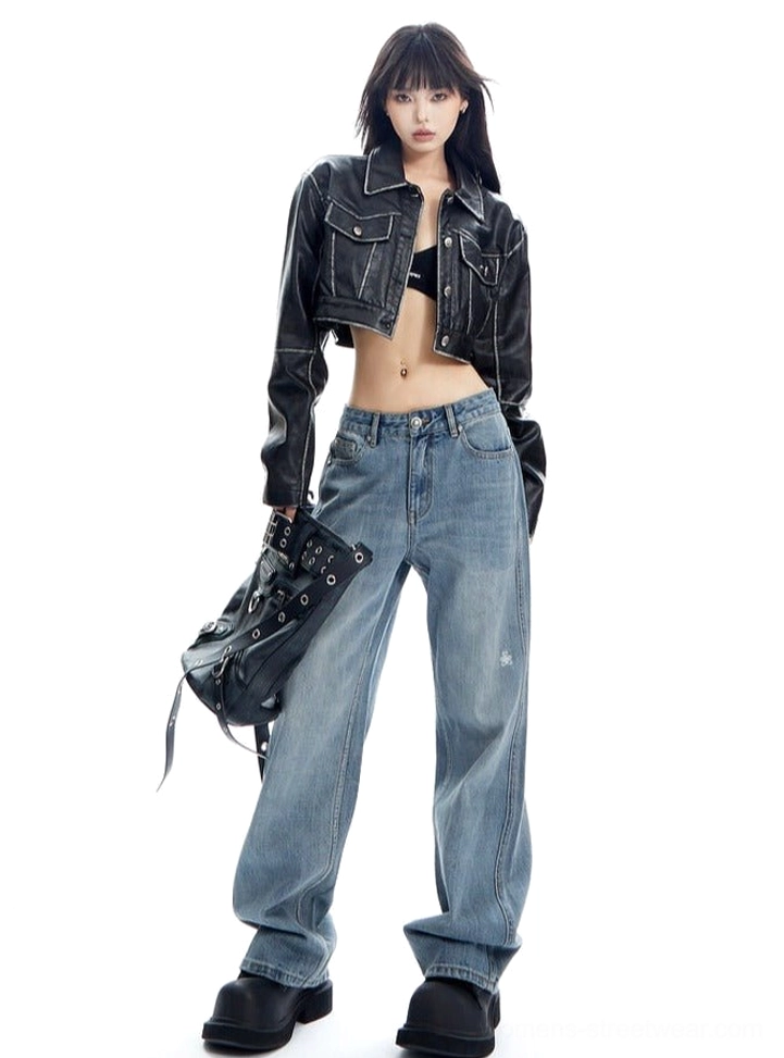 Front three-quarter view of light wash wide-leg denim jeans styled with a black cropped jacket and studded biker shoulder bag