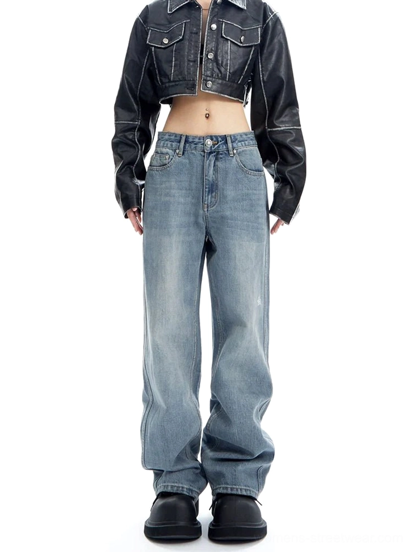 Front full-body view of light wash wide-leg denim jeans styled with a cropped black leather jacket and chunky black shoes in a minimalist streetwear outfit