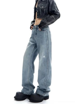 Three-quarter side view of light wash wide-leg jeans showing the relaxed silhouette, natural drape, and subtle knee distressing