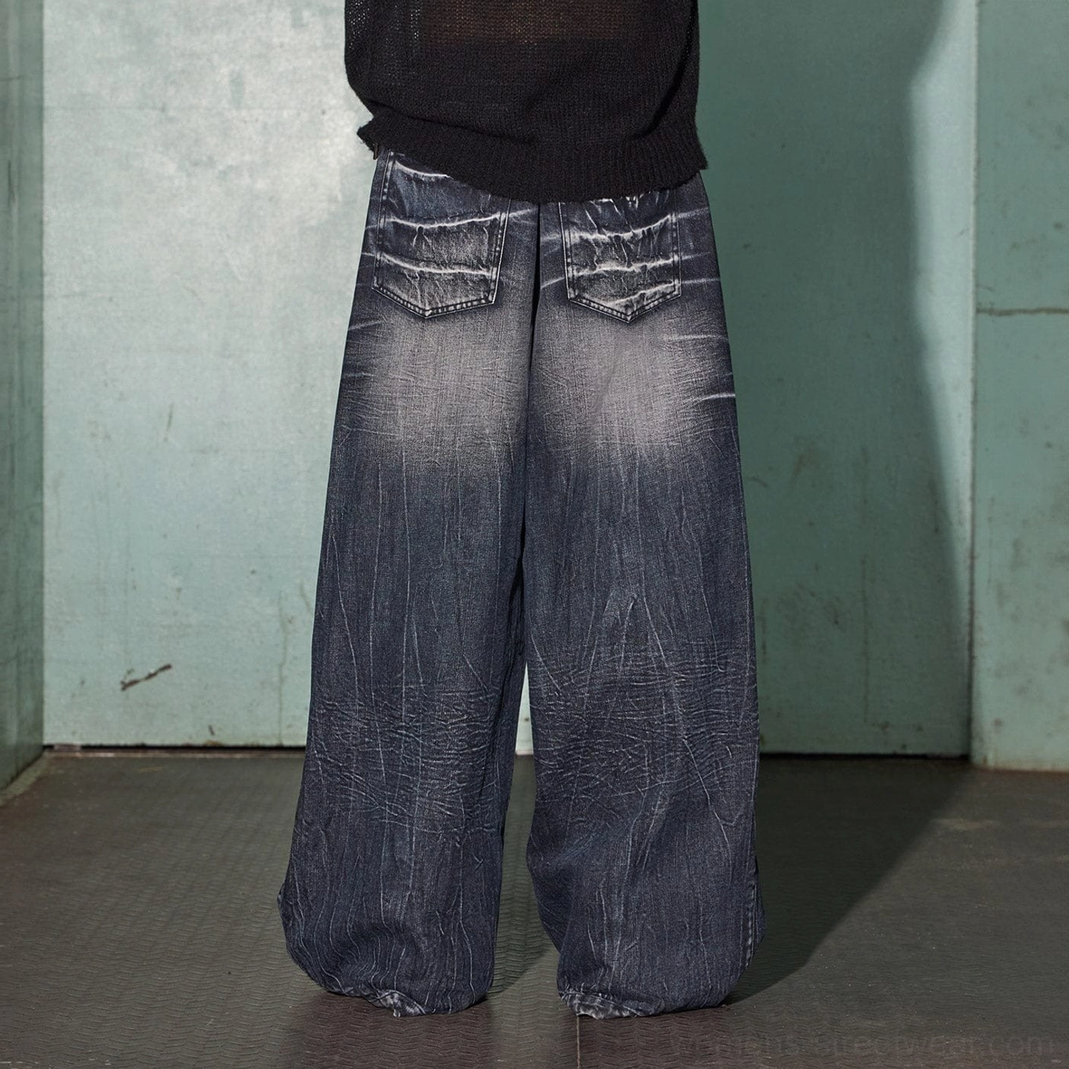 Rear view of oversized lightning wash wide-leg jeans showing rear patch pockets and washed denim detailing