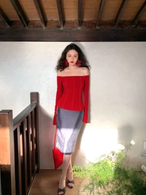 Lime high-waisted satin midi pencil skirt with luminous finish styled with a red off-shoulder top and handbag in a Seoul-inspired indoor setting