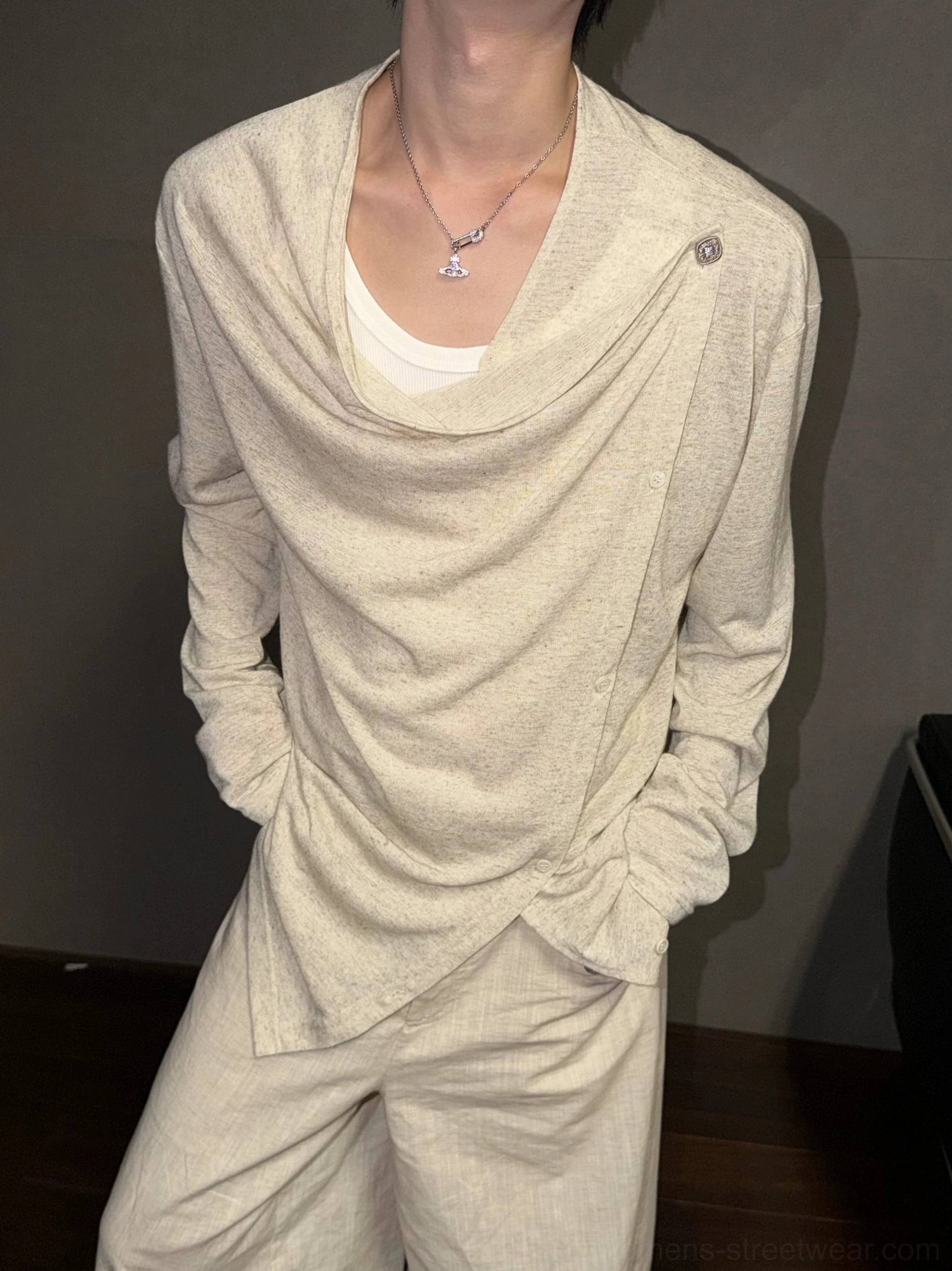 Linen beige asymmetric draped button long-sleeve streetwear top shown on a model with a gathered cowl neckline and layered styling