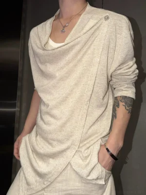 Three-quarter view of linen beige asymmetric draped button streetwear top with off-center fastening and relaxed long sleeves