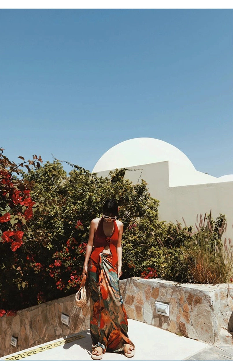 Long abstract printed tie-waist maxi skirt flowing in a bougainvillea courtyard with strappy flat sandals