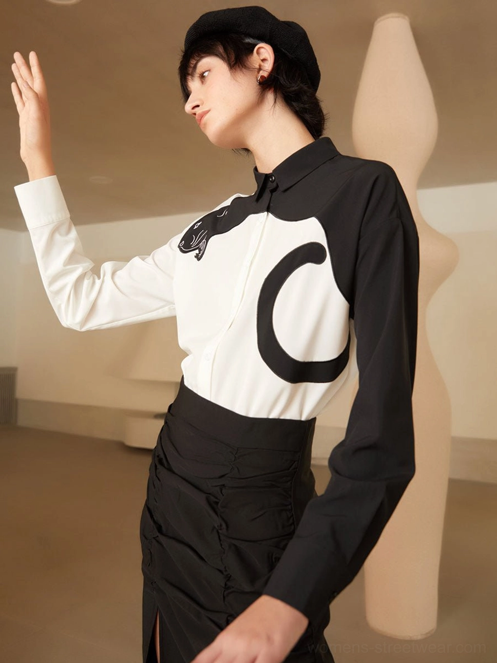 Side three-quarter view of long sleeve panther embroidered blouse with black beret and ruched skirt outfit