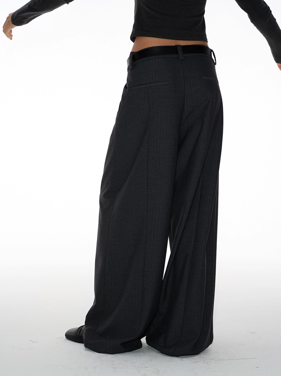 Back three-quarter close view of long wide-leg suit trousers with a subtle pinstripe texture, belt loops, and floor-length openings