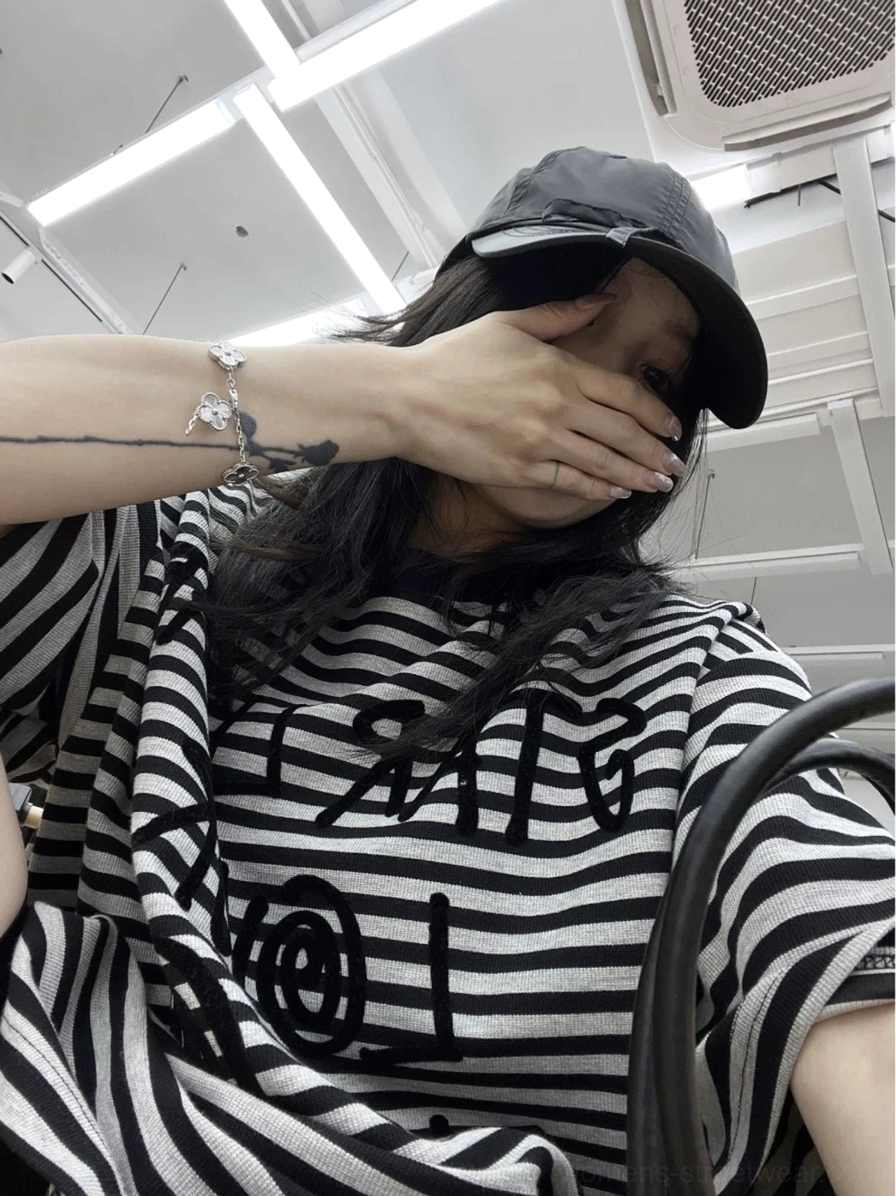 Half-body mirror outfit featuring a loose oversized black striped graphic tee with dropped short sleeves and modern streetwear proportions