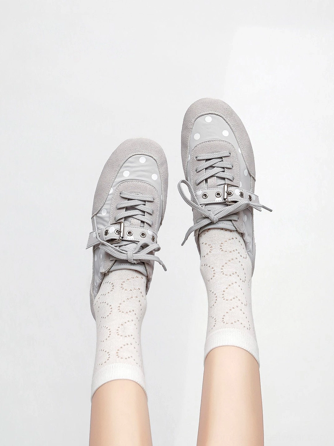 Low-profile polka dot ballet sneakers with buckle strap in a clean streetwear product presentation