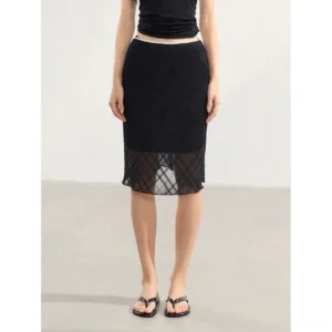 Back view of a low-rise black midi skirt featuring a delicate lace waistband and sheer plaid mesh hem