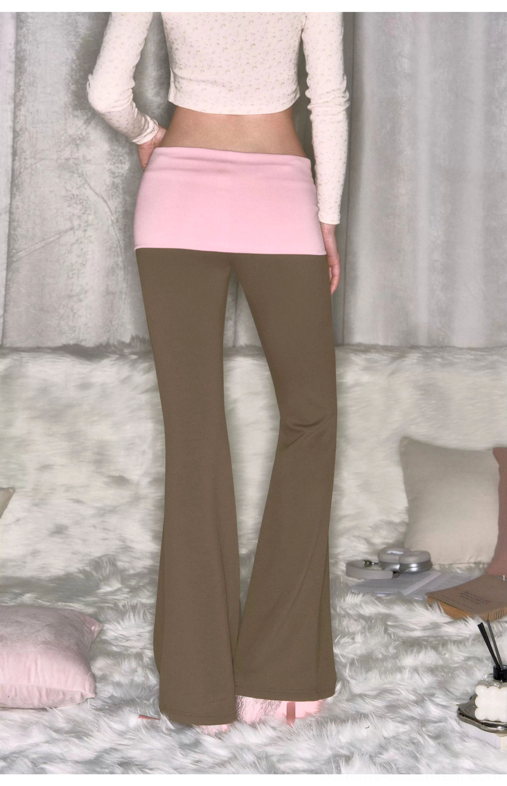 Back full-body view of khaki low-rise micro flare yoga pants with contrast pink fold-over waistband