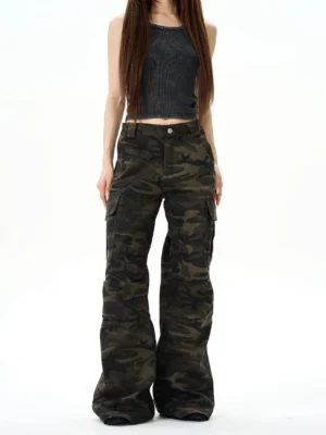 Front full-body studio view of low-rise dark camouflage wide-leg multi-pocket cargo pants styled with a cropped charcoal tank top