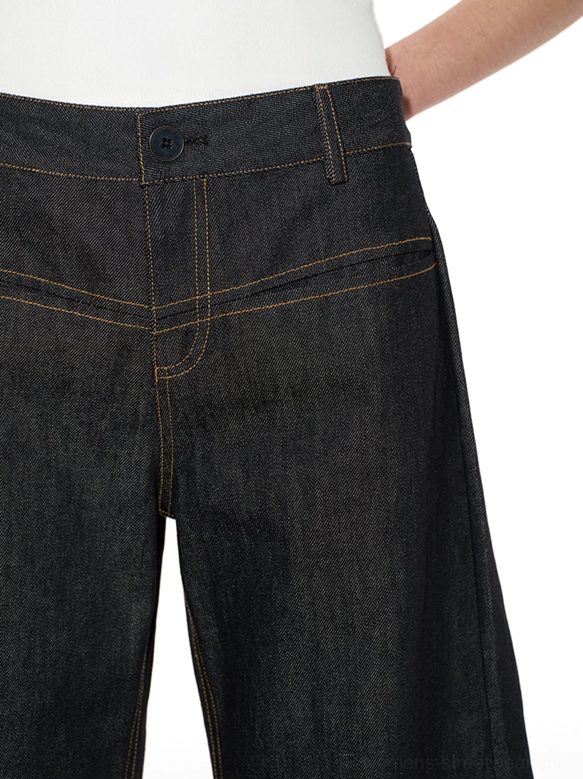 Close-up of low-rise raw denim jeans waistband front pockets coin pocket belt loops and contrast yellow topstitching