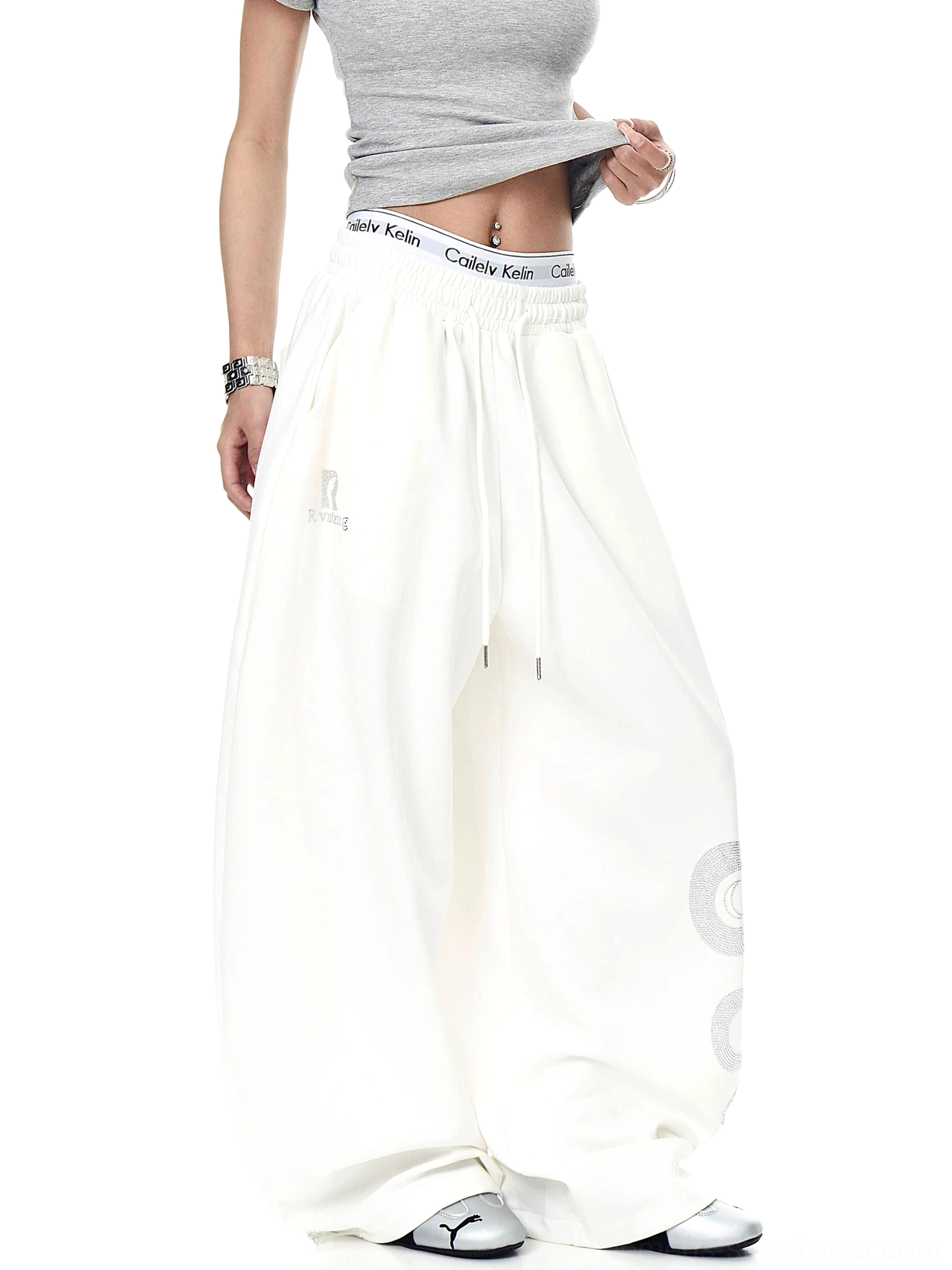 Off-white oversized Lunar Serpent streetwear sweatpants shown from a side angle with wide legs, thigh graphic, and adjustable drawstring waistband