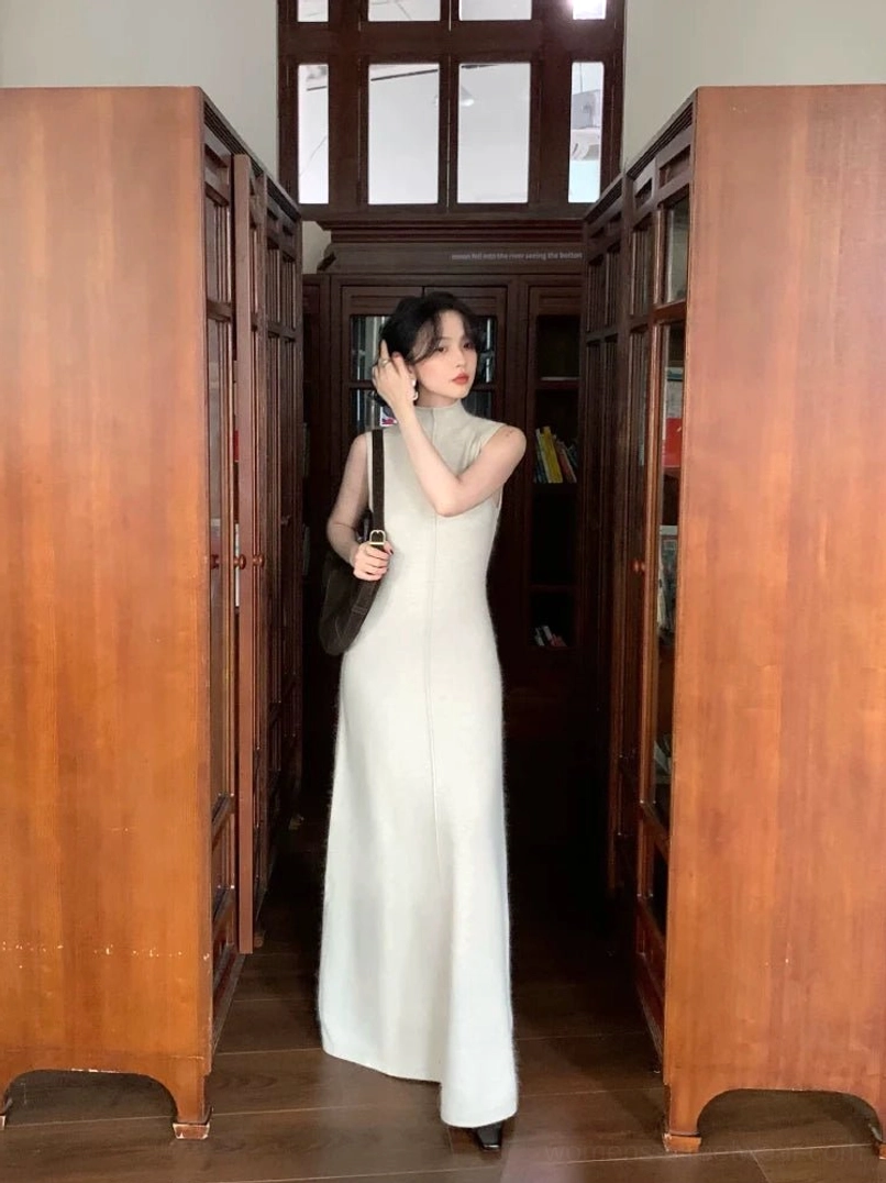 Maben light neutral sleeveless mock neck maxi knit dress with a slim floor-length silhouette styled indoors
