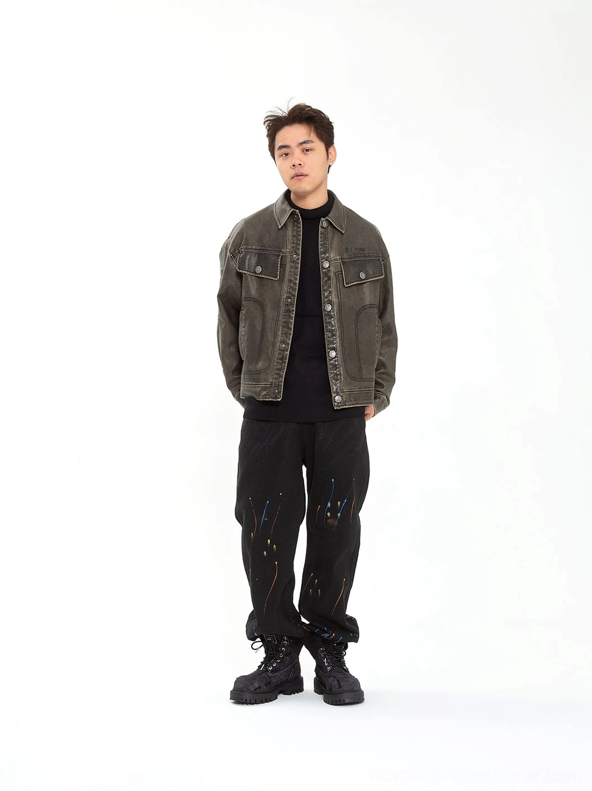 Male model wearing black platform combat boots with a dark denim jacket black top printed cargo pants and streetwear look