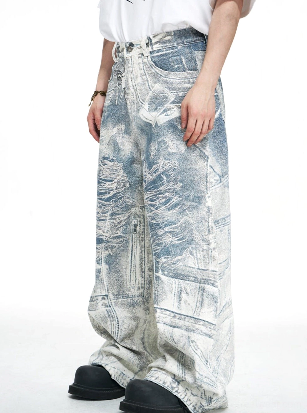 Male model wearing high-waisted blue acid-wash wide-leg baggy jeans with a white T-shirt and relaxed streetwear styling