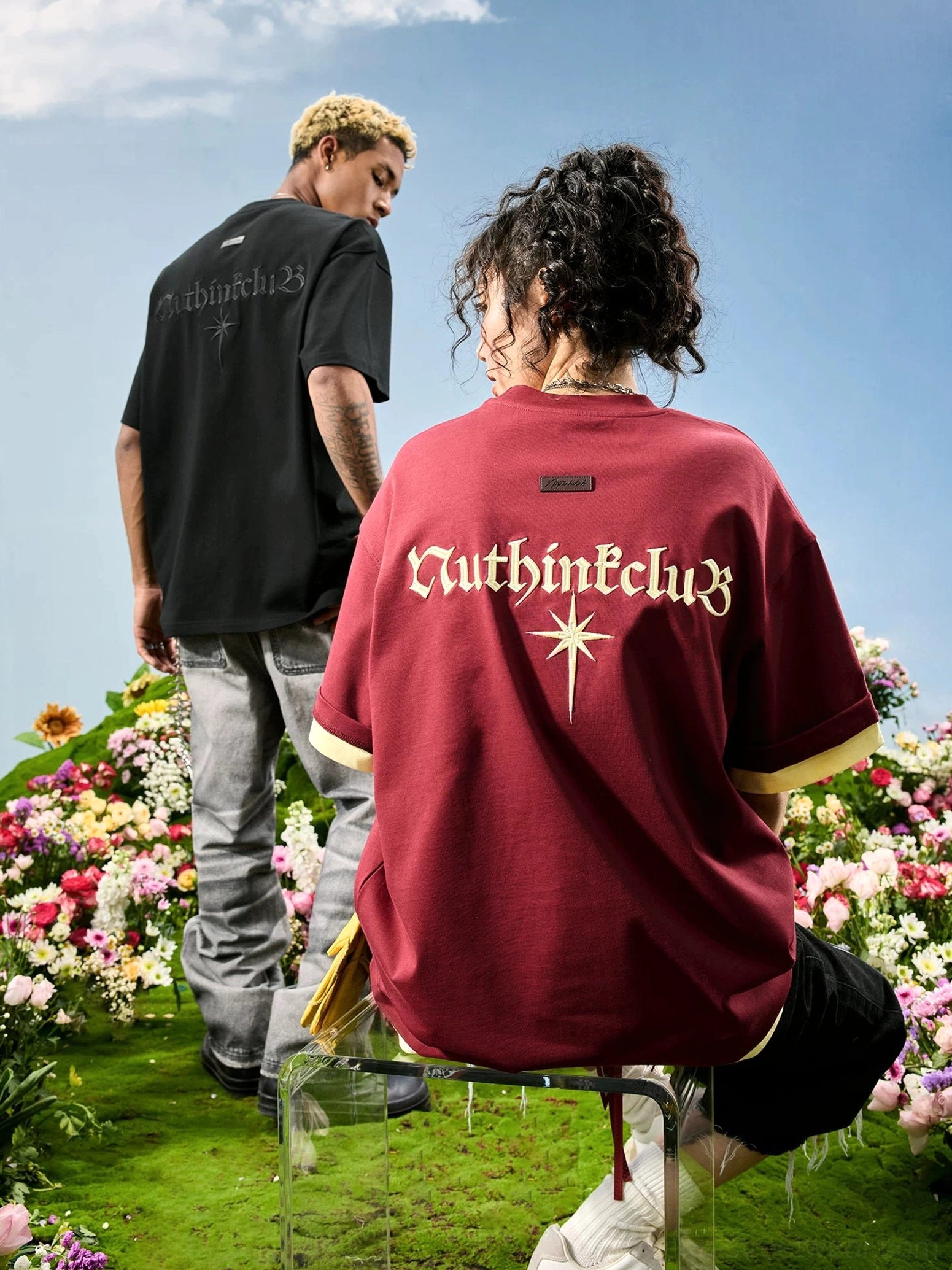 Maroon oversized Gothic embroidered T-shirt shown from the back on female model, featuring contrast faux layered cuffs and hem