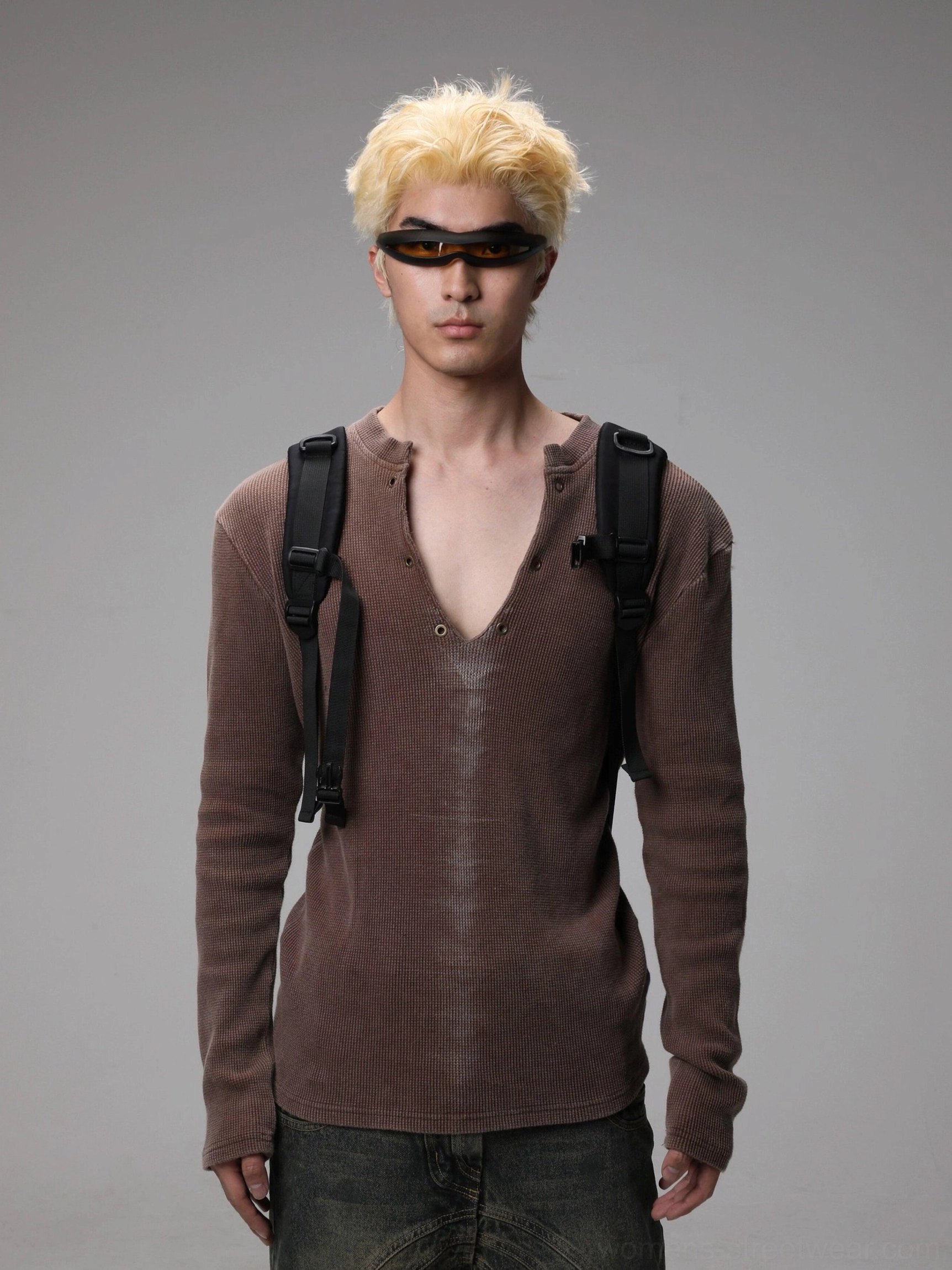 Maroon washed Henley knit sweater styled on a model with dark jeans, sunglasses, and backpack in a Seoul streetwear outfit
