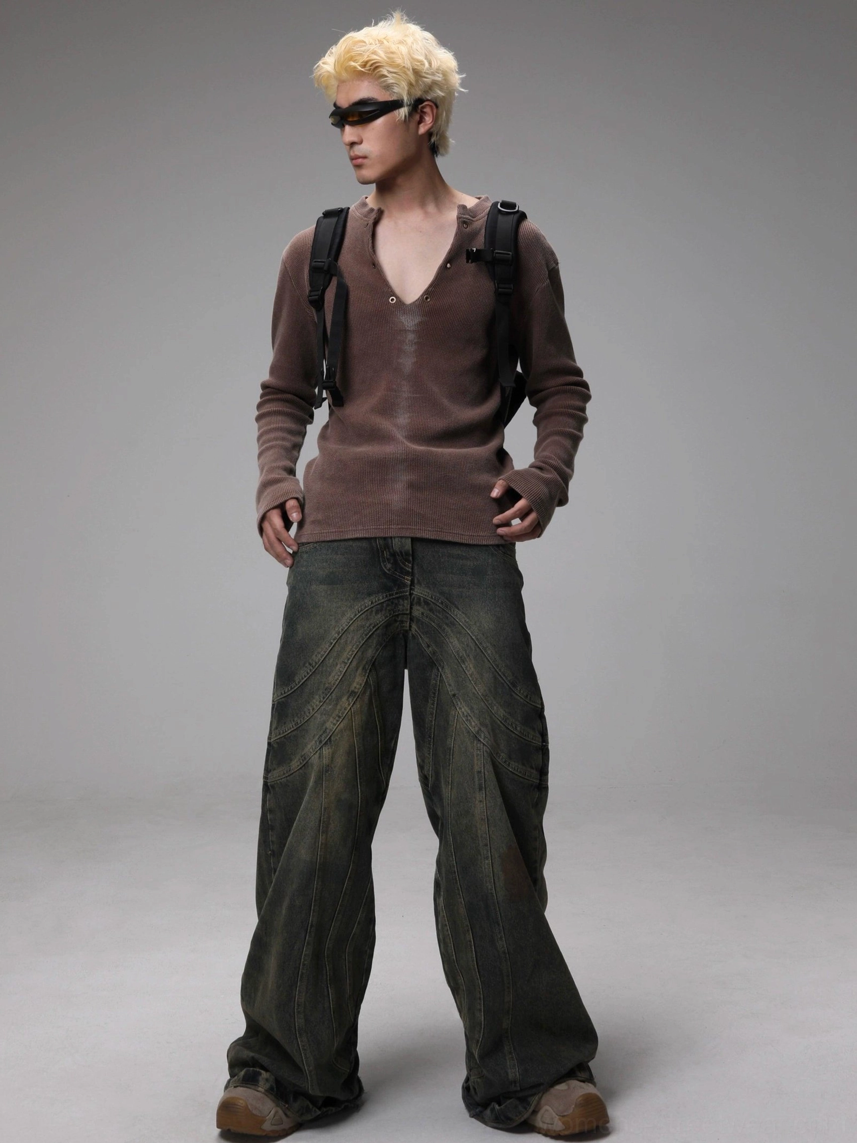 Full body front view of maroon washed Henley knit sweater paired with wide-leg dark denim