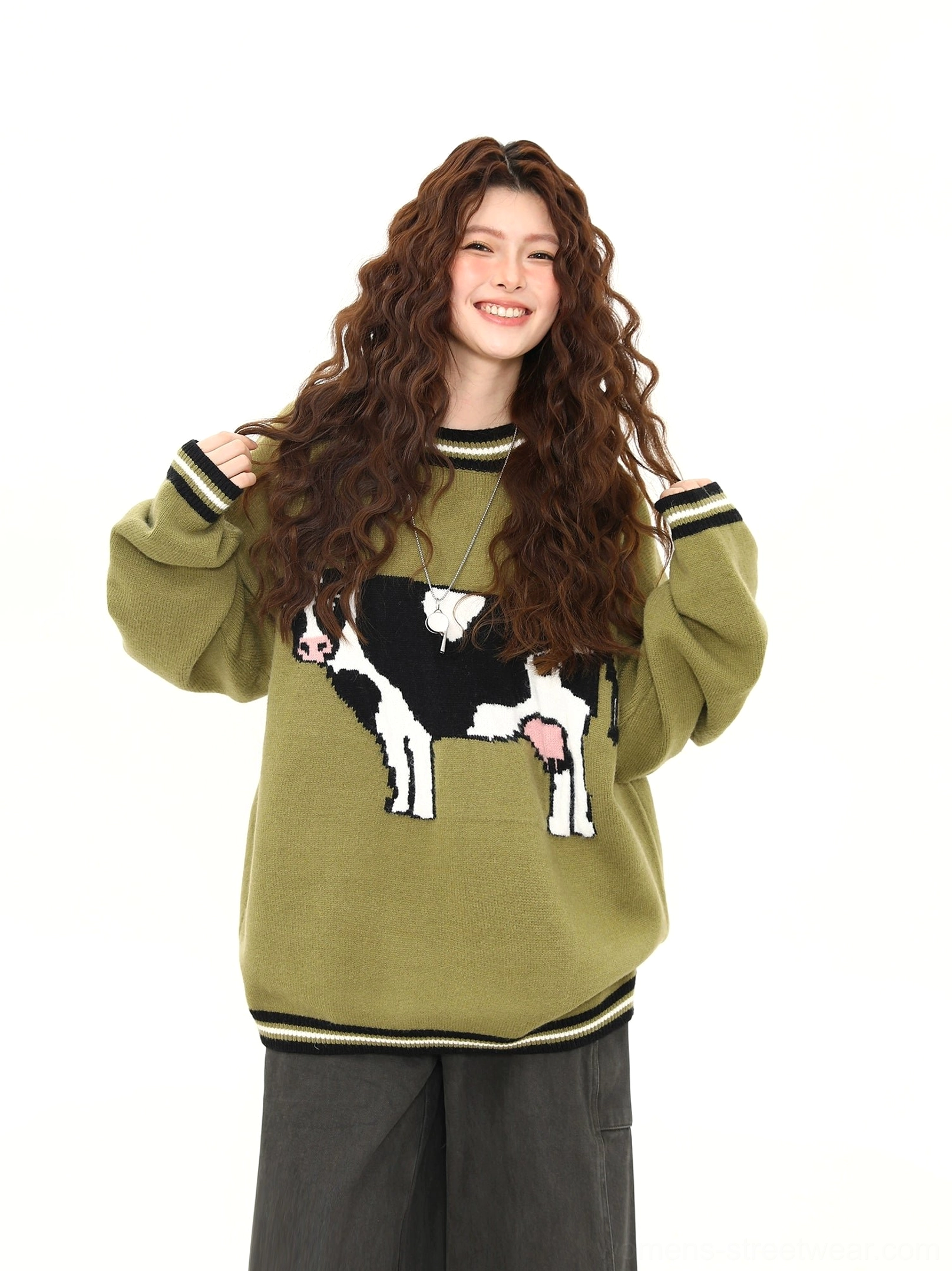 Cow jacquard oversized knit sweater in matcha green shown in a front three quarter studio view