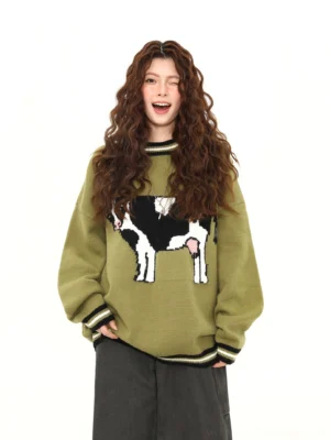 Matcha green cow jacquard oversized knit sweater front view styled with dark wide leg pants