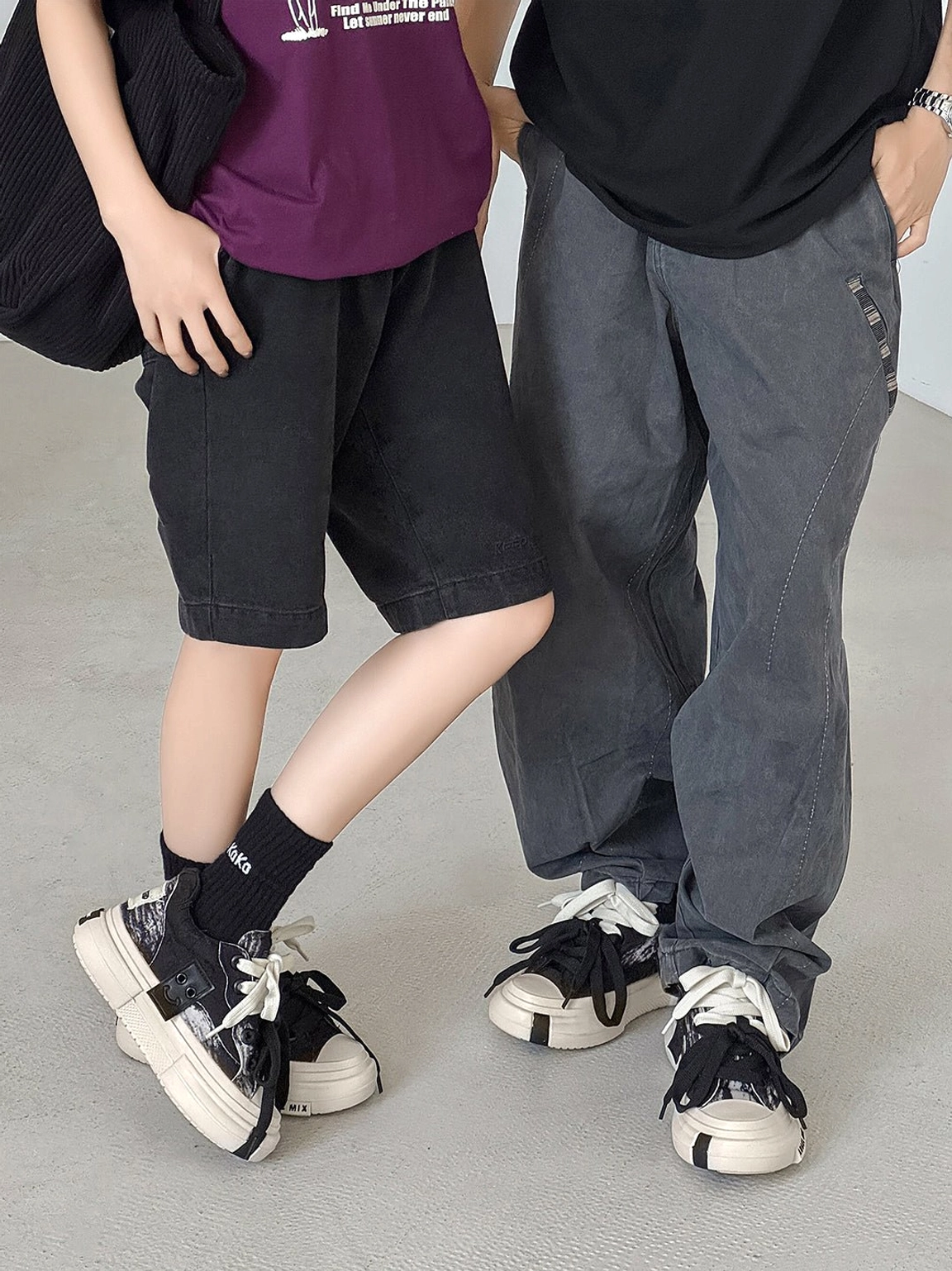 Two streetwear models wearing matching black and white canvas platform sneakers with relaxed casual outfits