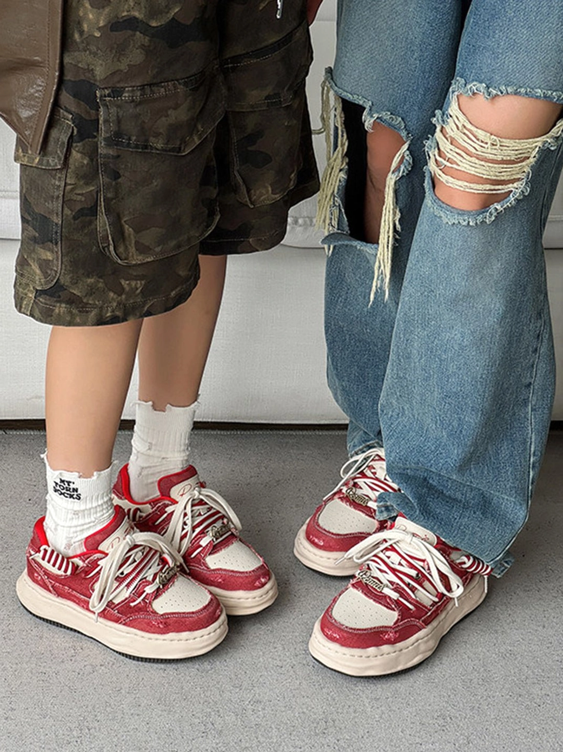 Pair of matching vintage washed denim platform sneakers shown with ripped jeans, camo shorts, and white crew socks
