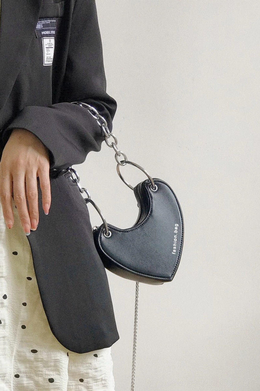 Matte black heart-shaped mini chain bag with silver hardware hanging side view