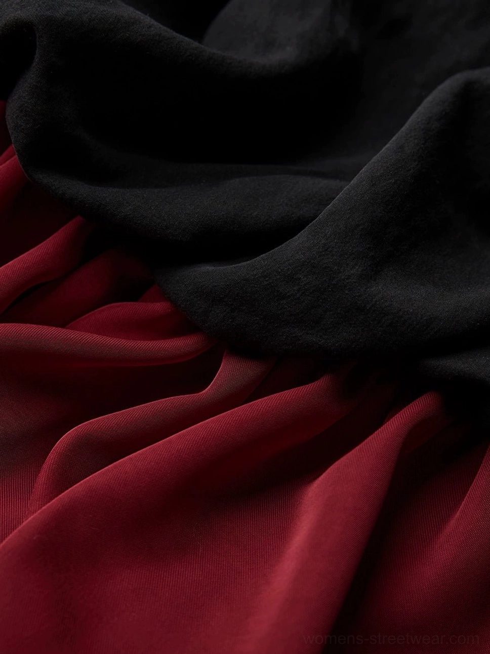 Close-up of matte black skirt fabric and glossy wine red lining on gothic patchwork maxi skirt