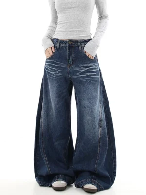 Female model wearing medium blue washed wide-leg flare jeans with oversized Y2K silhouette and tiger stripe denim fading