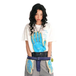 White acupuncture hand graphic streetwear t-shirt styled with low-rise grey pants and layered waist accessories