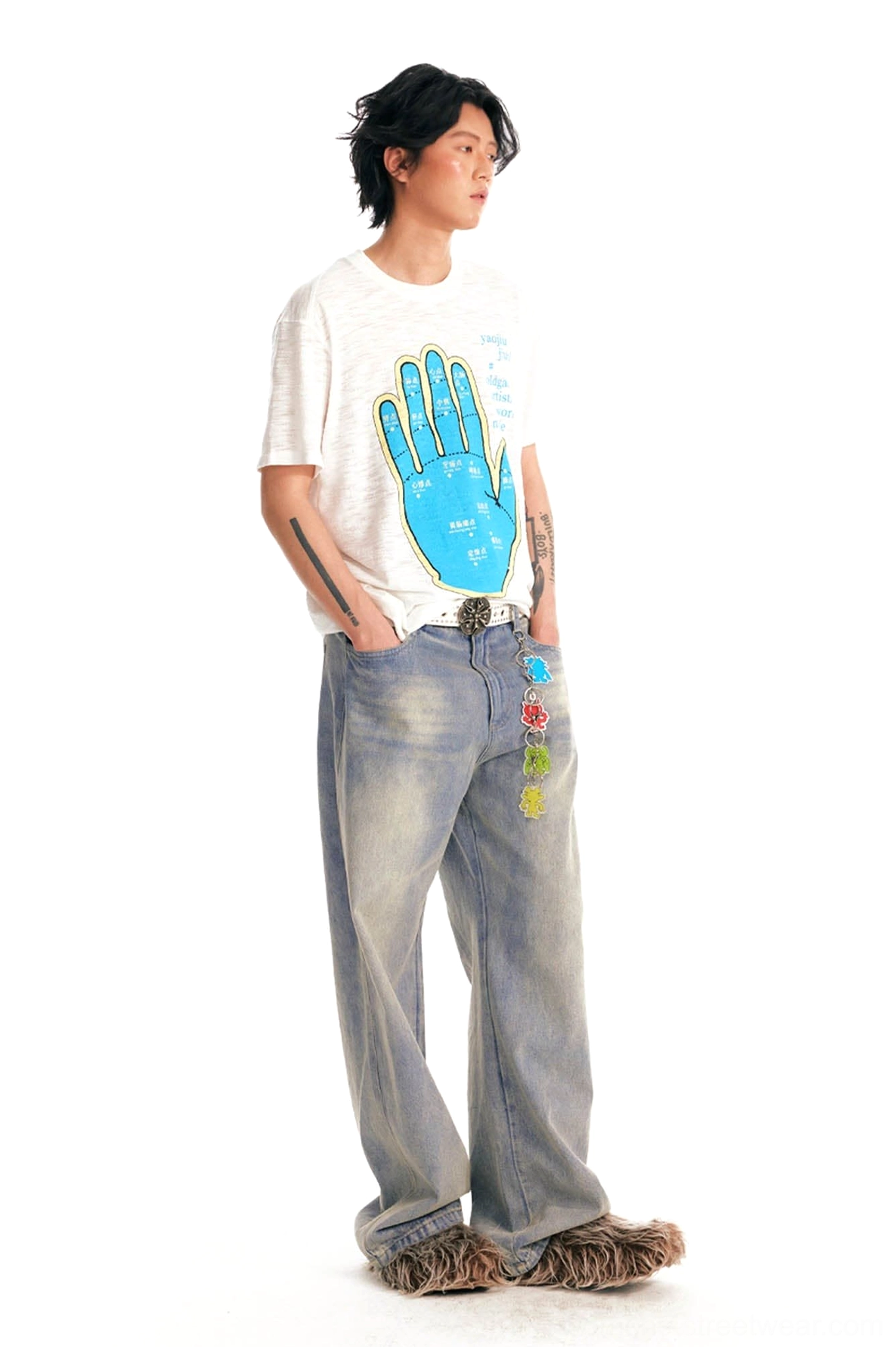 Side view of male model wearing textured slub cotton acupuncture hand graphic t-shirt with vintage jeans